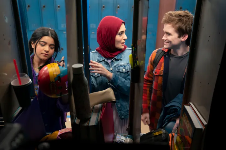 3 amigos conversam em frente aos lockers de uma escola dos Estados Unidos. Kamala Khan e seus amigos, na série Ms. Marvel